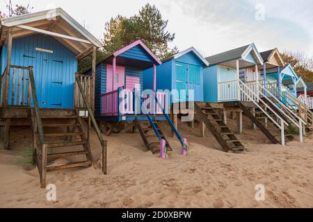 Strandhütten und Sandstrand bei Brunnen am Meer An der norfolk Küste uk Winter Sonnenschein england Stockfoto