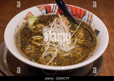 Special Black Tan Tan Ramen, japanische, würzige Nudelsuppe mit gehacktem Schweinefleisch, schwarzem Sesam, Chili-Öl und Chili-Bohnenpaste. Stockfoto