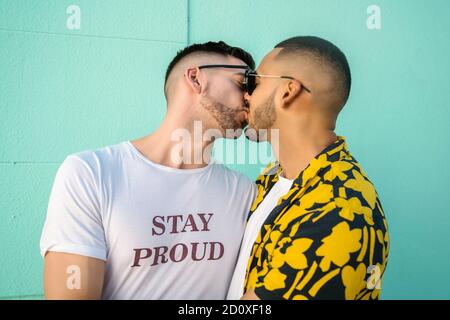 Porträt eines fröhlichen schwulen Paares, das auf der Straße umarmt und küsst. LGBT und Love Konzept. Stockfoto