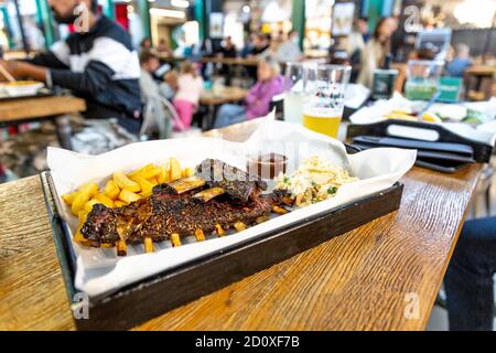 Grillrippen mit Pommes und Krautsalat im Kiełba w Gębie Polish Food Stall, Hala Koszyki, Warschau, Polen Stockfoto