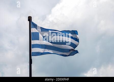 Flagge Griechenlands auf Fahnenmast auf Wolken Hintergrund Stockfoto