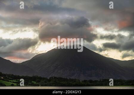 Atemberaubendes Landschaftsbild bei Sonnenaufgang mit Blick über Loweswater im See Bezirk in Richtung Low Fell und Grasmere mit bunten Himmel brechen Auf dem Berg Stockfoto