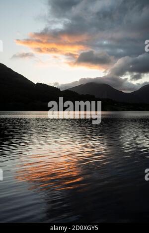 Atemberaubendes Landschaftsbild bei Sonnenaufgang mit Blick über Loweswater im See Bezirk in Richtung Low Fell und Grasmere mit bunten Himmel brechen Auf dem Berg Stockfoto