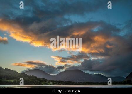 Atemberaubendes Landschaftsbild bei Sonnenaufgang mit Blick über Loweswater im See Bezirk in Richtung Low Fell und Grasmere mit bunten Himmel brechen Auf dem Berg Stockfoto