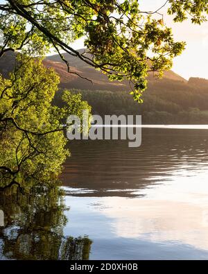 Atemberaubendes Landschaftsbild bei Sonnenaufgang mit Blick über Loweswater im See Bezirk in Richtung Low Fell und Grasmere mit bunten Himmel brechen Auf dem Berg Stockfoto