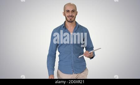 Arab Presenter zu Fuß mit digitalen Tablet Wischen Seiten darauf o Stockfoto