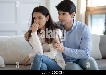 Ehemann umarmt Schultern des Schreiens beleidigte Frau schlägt vor, sich zu versöhnen Stockfoto