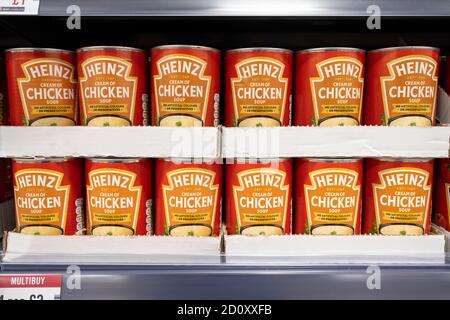 Dosen von Heinz Hühnersuppe auf einem Supermarktregal in Cardiff, Wales, Vereinigtes Königreich. Stockfoto