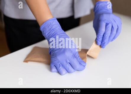 Meister der Maniküre in Gummihandschuhen öffnen Werkzeuge nach dem Sterilisieren Stockfoto