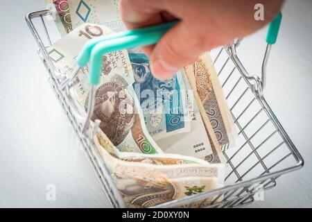 Warenkorb gefüllt mit Geld aus Polen. Das Konzept der steigenden Preise in den Geschäften und der steigenden Inflation Stockfoto