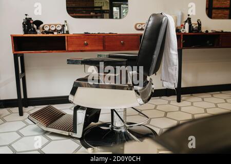 Bild von verstellbaren Stuhl in einem Friseurladen auf sechseckig-gemustert Boden Stockfoto