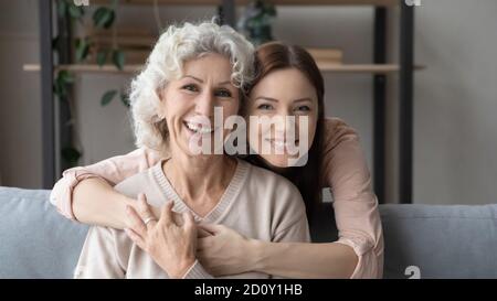 Kopf erschossen Porträt junge Frau umarmt reife Mutter von hinten Stockfoto