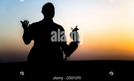 Dubai, VAE - Juni 2013: Falcon Trainer Silhouette in der Wüste mit Sonnenuntergang Landschaft Stockfoto