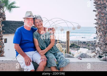 Glückliches Seniorenpaar umarmen mit Liebe und genießen gemeinsam im Freien Freizeitaktivitäten - Konzept der Sommertouristen und Meerblick Im Hintergrund Stockfoto