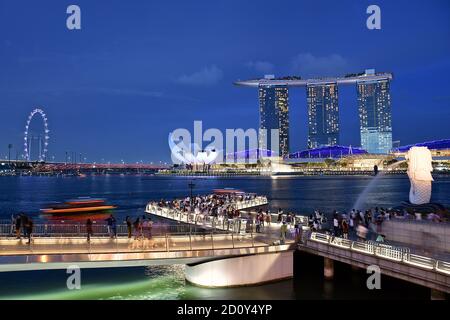 SINGAPUR - 24. JULI 2019 - Marina Bay Sands Hotel, The Merlion und der Singapore Flyer bei Nacht. Stockfoto