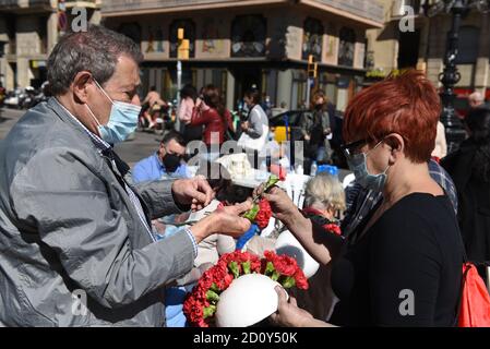 Barcelona, Spanien. Oktober 2020. Menschen tragen Gesichtsmasken bereiten Blumensträuße während der Feier des Roser de La Rambla Festival.Roser Festival wird jedes Jahr ohne weiteres seit 1962 statt. Nachbarn dieses Viertels im Zentrum von Barcelona schmücken Straßen und Gebäude mit Blumen zu Ehren der Jungfrau vom Rosenkranz, schutzpatronin der berühmten Straße La Rambla. Kredit: SOPA Images Limited/Alamy Live Nachrichten Stockfoto