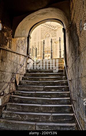 Alte römische Treppe unter einem überdachten Steingewölbtunnel, in der historischen englischen Stadt Bath. Stockfoto