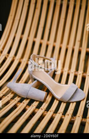 Brautsandalen aus nächster Nähe auf einem Stuhl aus Holzstäben. Stockfoto