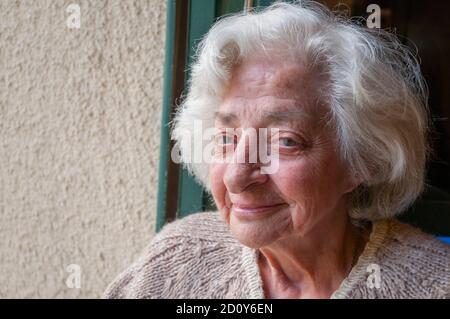 Porträt der alten Dame lächelt und schaut in die Kamera. Stockfoto