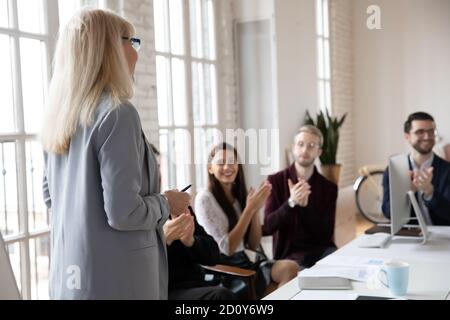 Die begeisterte Mitarbeiterin applaudiert der Trainerin zur Präsentation Stockfoto