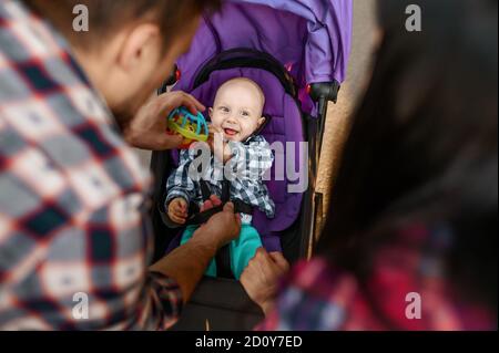 Vater spielt mit seinem kleinen Sohn im Kinderwagen Stockfoto