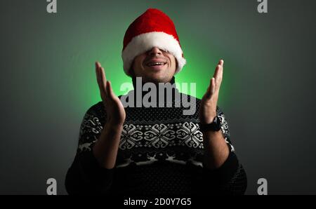 Lustige Mann in einem Weihnachtsmann Hut auf einem grünen Hintergrund, Stockfoto
