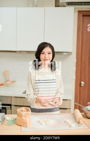 Frauen backen Kuchen. Konditoren machen Desserts. Brötchen machen. Teig auf dem Tisch. Den Teig kneten. Stockfoto