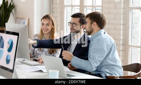 Lächelnde Kollegen haben Spaß am Computer im Büro Stockfoto
