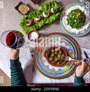 Frau, die Dolma isst, mit Rotwein von oben Stockfoto