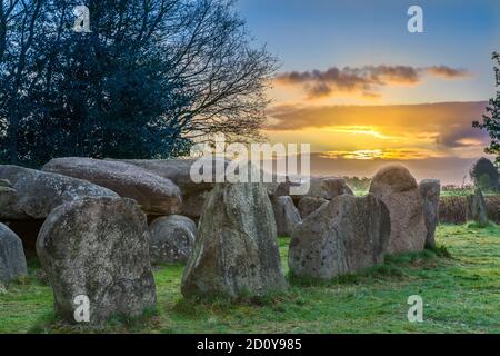 Dolmen bei Sonnenaufgang mit Wolken und grünem Gras Stockfoto