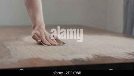 Mann Hand Schleifen schwarzen Nussbaum Holztisch, breites Foto Stockfoto