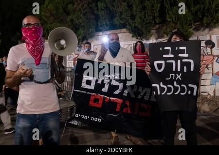 JERUSALEM, ISRAEL - 03. OKTOBER: Ein pro-Netanjahu-Gegenprotest mit einem Banner mit der Aufschrift "Linke sind Verräter" steht inmitten von Anti-Netanjahu-Demonstranten während einer Demonstration vor dem offiziellen Wohnsitz des Premierministers trotz einer landesweiten Sperre, die darauf abzielt, die Coronavirus-Pandemie am 03. Oktober 2020 in Jerusalem, Israel, einzudämmen. Das israelische parlament hat letzte Woche ein Gesetz verabschiedet, das Demonstrationen als Teil eines mit dem Coronavirus in Verbindung stehenden Ausnahmezustands einschränkt. Kritiker sagen, dass es darauf abzielt, Proteste gegen Netanjahu wegen seiner Anklageschrift wegen Korruptionsvorwürfen zum Schweigen zu bringen Stockfoto