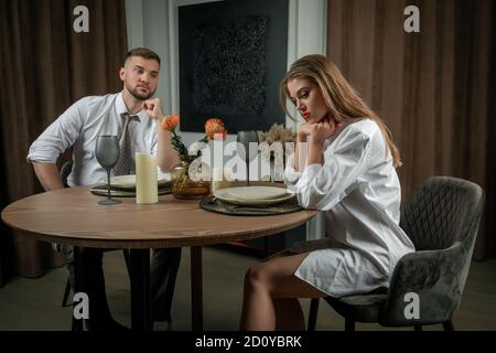 Junges Paar sitzt am Tisch während des Abendessens nach Streit Stockfoto