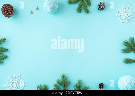 Weihnachtskomposition. Weihnachtsdekor, Tannenzapfen, Tannenzweige und Schauflocken auf blauem Hintergrund. Flach liegend, Draufsicht, Kopierbereich. Stockfoto