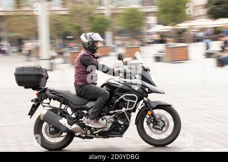 Belgrad, Serbien - 02. Oktober 2020: Mann auf einem schnellen Motorrad mit hinterer Box in der leeren Straße am Stadtplatz, Schwenken erschossen Stockfoto