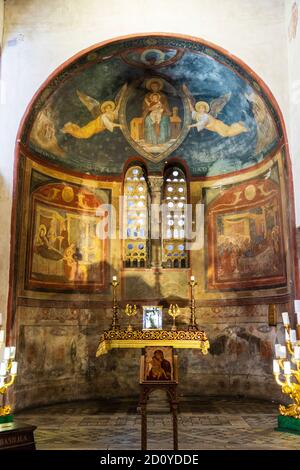 Linke Apsis, die der Muttergottes von Loreto gewidmet ist, mit Altar und Fresken aus dem 19. Jahrhundert, die durch aufsteigende Feuchtigkeit beschädigt wurden, in der Kirche Santa Maria in Cosmedin, Rom. Stockfoto