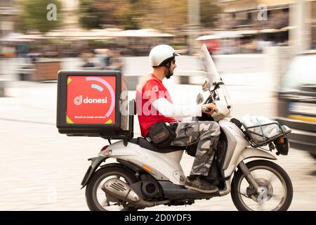 Belgrad, Serbien - 02. Oktober 2020: Kurier arbeitet für die Stadt Donesi Food Delivery Service auf einem Roller Motorrad in der Stadt Straße Stockfoto