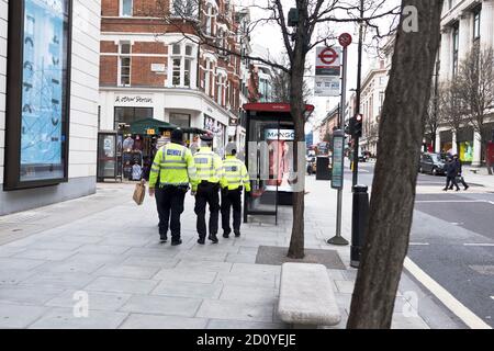 dh Police OXFORD STREET LONDON ENGLAND Großbritannien drei Polizisten auf Schlagen Sie den kleinen, kurzen Polizisten, der mittelgroß ist Stockfoto