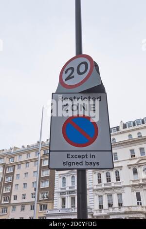 dh KENSINGTON LONDON 20 mph Speed Limit Zeichen Parkplatz Eingeschränkte Zone Wegweiser Beschränkungszeichen england uk Beschränkungen Stockfoto