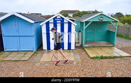 Worthing UK 4. Oktober 2020 - Läufer beim Virtual London Marathon kämpfen an einem nassen und windigen Tag an der Ferring-Küste bei Worthing gegen die Elemente, während sie ihre 20-Meilen-Marke erreichen : Credit Simon Dack / Alamy Live News Stockfoto