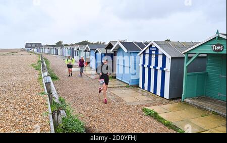 Worthing UK 4. Oktober 2020 - Läufer beim Virtual London Marathon kämpfen an einem nassen und windigen Tag an der Ferring-Küste gegen die Elemente, während sie nach Hause zurück nach Worthing fahren, während sie ihre 20-Meilen-Marke passieren : Credit Simon Dack / Alamy Live News . Stockfoto