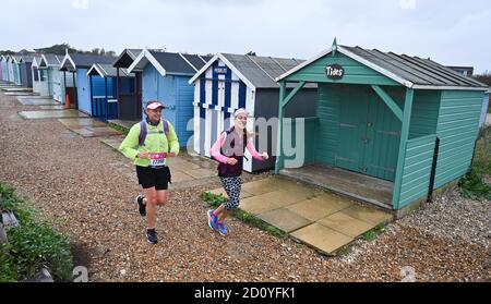 Worthing UK 4. Oktober 2020 - Läufer beim Virtual London Marathon kämpfen an einem nassen und windigen Tag an der Ferring-Küste gegen die Elemente, während sie nach Hause zurück nach Worthing fahren, während sie ihre 20-Meilen-Marke passieren : Credit Simon Dack / Alamy Live News . Stockfoto