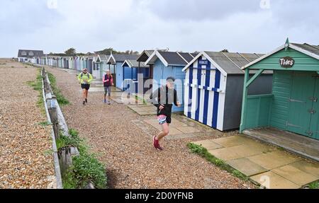 Worthing UK 4. Oktober 2020 - Läufer beim Virtual London Marathon kämpfen an einem nassen und windigen Tag an der Ferring-Küste gegen die Elemente, während sie nach Hause zurück nach Worthing fahren, während sie ihre 20-Meilen-Marke passieren : Credit Simon Dack / Alamy Live News . Stockfoto