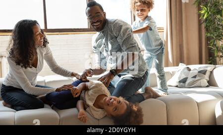 Überglücklich afroamerikanische Familie in lustige häusliche Aktivität beteiligt. Stockfoto