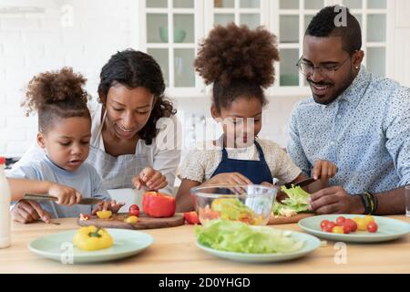 Glückliches Paar genießen die Zubereitung von Essen mit Kindern. Stockfoto