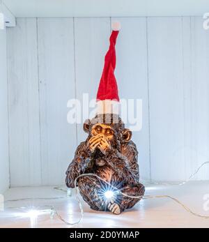Die drei Affen Skulptur sprechen nicht weihnachten Decoation weihnachtsmütze und Lichter. Stockfoto
