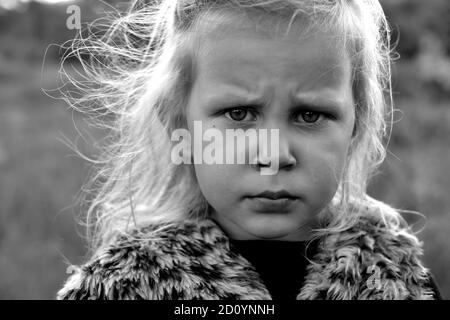 Kinderportrait, Nahaufnahme. Mädchen im Freien in der Natur. Schönes Mädchen 3 Jahre alt. Herbstfoto. Düsteres Kind. Emotionen von Kindern. Schwarz und Weiß Stockfoto