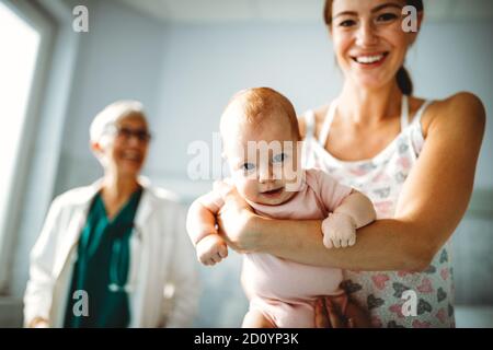 Kinderarzt mit Mutter und Baby bei der Untersuchung im Krankenhaus. Heiratlhcare, Familie, Arzt Konzept. Stockfoto