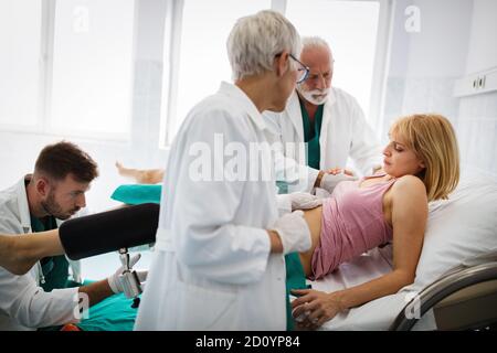 In dem Krankenhaus treibt die Frau in der Arbeit die Geburt voran, Geburtshelfer helfen Stockfoto
