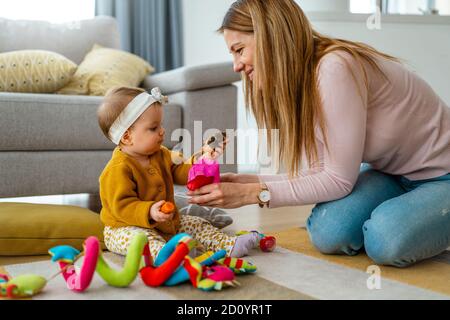 Kind Mädchen und ihre Mutter spielen zusammen mit Spielzeug und Spaß zu Hause Stockfoto